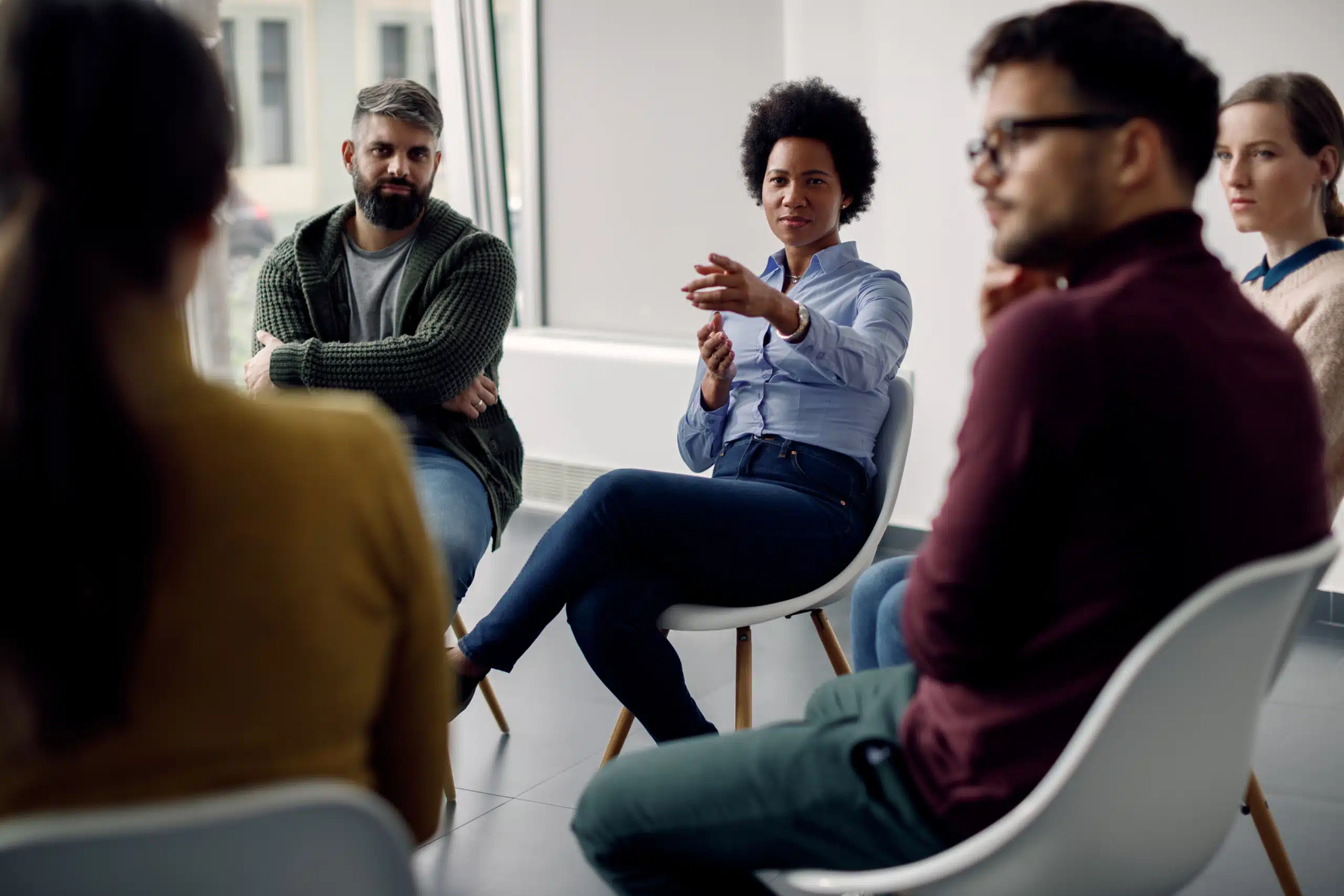 People sit in a circle at a group therapy session